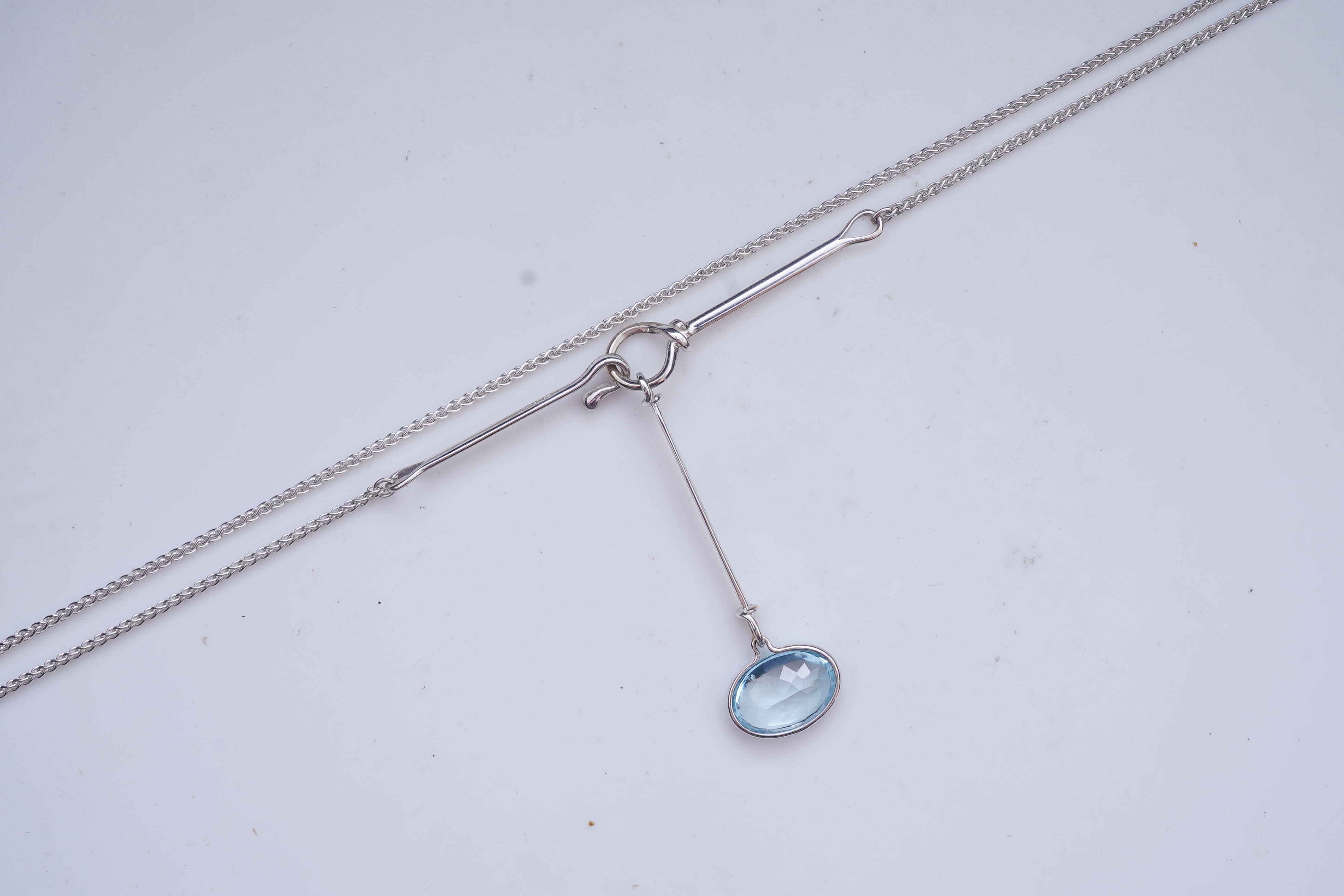 Georg Jensen, a blue topaz necklace, centring on a hook clasp suspending an oval blue topaz pendant, pendant length 5.5cm, necklace length 43cm, stamped GJ for Georg Jensen, 925S and European convention assay marks for s